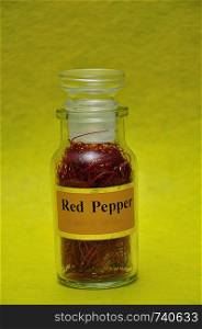 A jar filled with red pepper on a yellow background