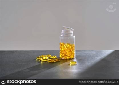 A jar of OMEGA 3 capsules stands on a table.. A jar of OMEGA 3 capsules stands on a dark table.