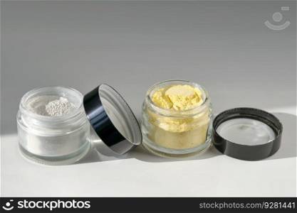 A jar of rice flour face enzime scrub and a jar of turmeric face scrub.. A jar of rice flour face scrub and a jar of turmeric face scrub.