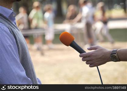 A journalist is making an interview with a microphone