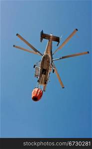 A KA32 helicopter firefighter take water to extinguish a forest fire in Spain