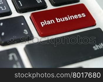 A keyboard with a red button plan business