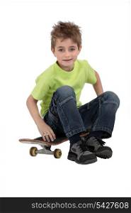 A kid sitting on his skateboard.