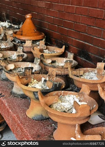 A kitchen at a roadside restaurant near Marrakech in Morocco is filled with clay barbecues for cooking tagines.