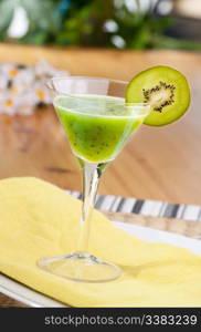 A kiwi based fruit drink in a martini glass