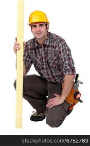 A kneeled male carpenter.