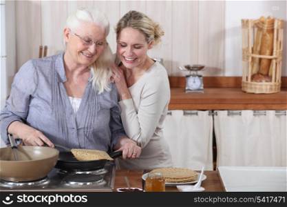 A lady and her daughter cooking crepes.