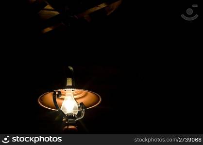 a lamp stylized as a kerosene one, in a dark room