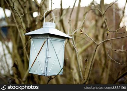 A lantern haning on a tree branch