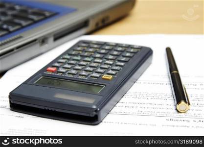 A laptop, calculator and accounting paperwork showing typical business environment setting