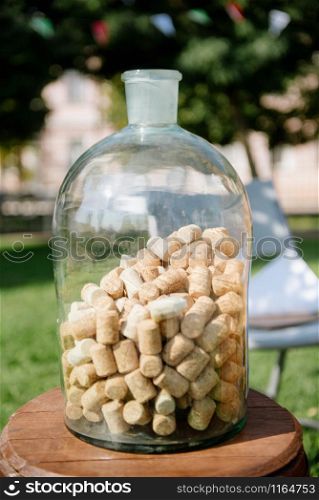a large glass transparent bottle with wooden corks inside. Many corks made of wood inside the bottle. large glass transparent bottle with wooden corks inside