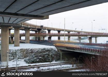 A large motorway junction with several fly-overs and viaducts on a snowy winter day