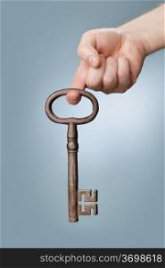 A Large old antique skeleton key hanging from a finger.