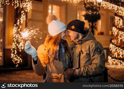 A large portrait of a couple in love on the background of the New Years lights of the city.. Love among the Christmas lights 3080.