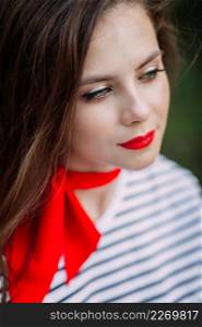 A large portrait of a girl with bright red lipstick.. A beautiful portrait of a woman with bright red lipstick and a scarf around