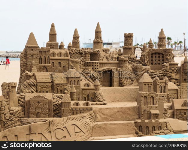 A lavish and large sand castle on an empty beach.