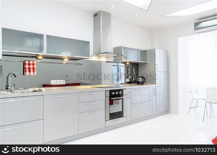 A light gray kitchen and a big windoe with a lot of light