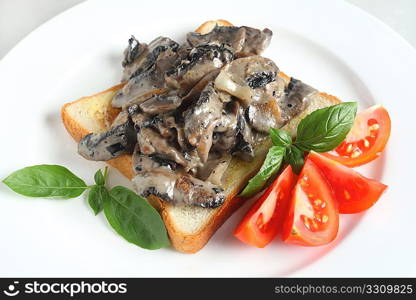 A light meal of mushrooms cooked with onion and garlic in a cream sauce served on toast with tomato and a garnish of basil