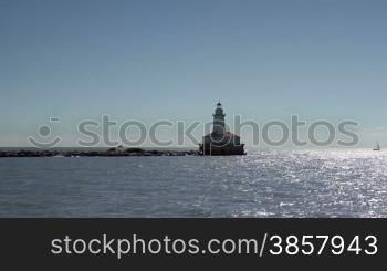 A lighthouse in Lake Michigan (Chicago Harbor Lighthouse) as seen from a boat speeding by it