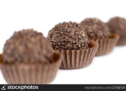 a line of chocolate round sweets in perspective, super macro