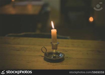 A lit candle on a table in a dining room