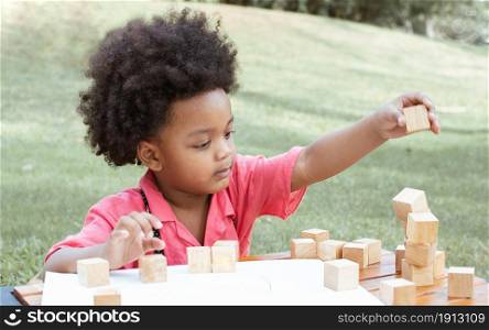 A little African black boy wearing pink shirt is playing in backyard. Education and Lifestyle Concept.