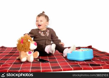 A little baby girl sitting on a blanket on the floor with her toy&rsquo;s and playing,isolated for white background.