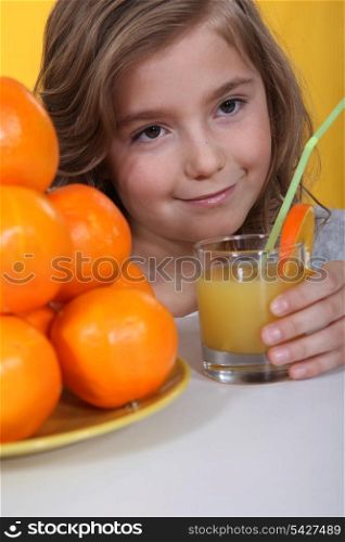 a little blonde girl drinking orange juice