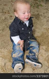 a little boy having fun in the sandbox