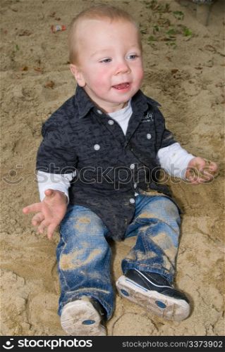 a little boy having fun in the sandbox