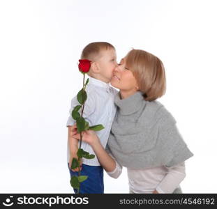 a little boy presenting his mother a red rose