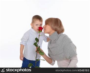 a little boy presenting his mother a red rose