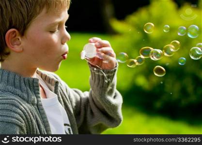 a little child blowing bubbles