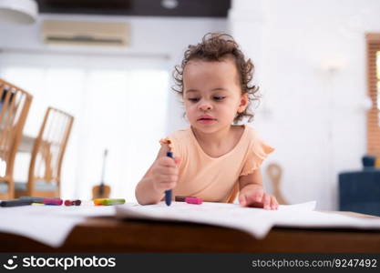 A little child’s imagination is represented through colored pencil drawings, with the mother attentively supervising in the living room of the house.