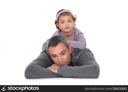 A little girl laying on her father&acute;s back.