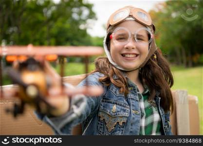 A little girl on vacation at the park with a pilot outfit and flying equipment. Run around and have fun with her dreams.