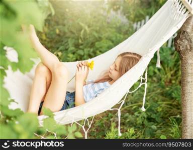 A little girl rests in a hammock and eats cherries in the summer.  Summer in the village. 