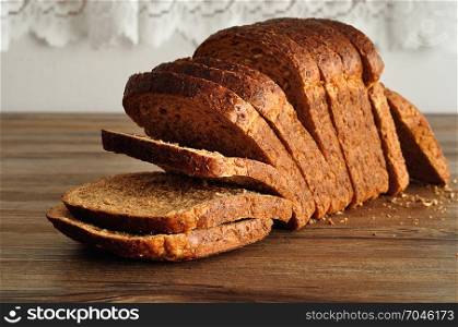 A loaf of whole wheat bread displayed on a wooden table