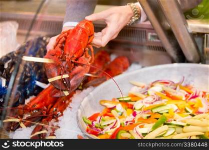 A lobster for a sale at a fresh seafood counter in a grocery store