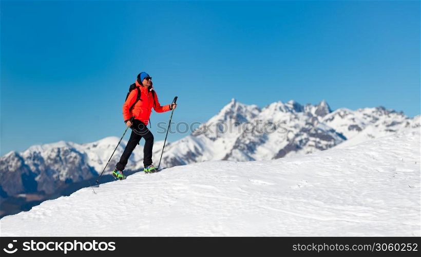 A lonely woman walks on the snow with crampons
