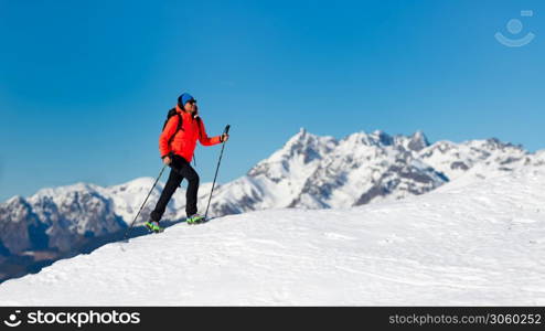 A lonely woman walks on the snow with crampons