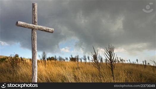 a lonely wooden cross on an autumn field