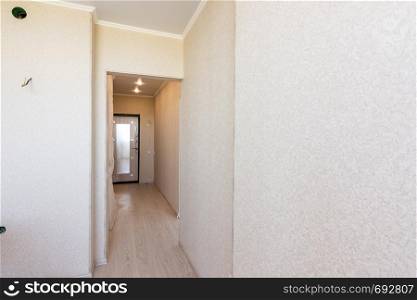 A long corridor in the apartment, going from the kitchen to the exit