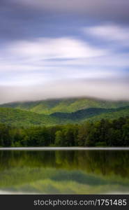 A long exposure showing the movement of clouds and fog enveloping the skyline of Shenandoah National Park, viewed from Lake Arrowhead near Luray.