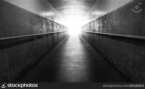 A long underground corridor leads up the the surface and the light at the end of the tunnel