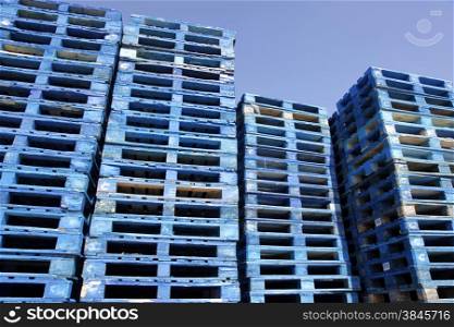a lot of blue pallets in sunshine with blue sky
