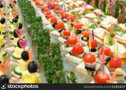 a lot of canapes with skewer on buffet table, shallow DOF