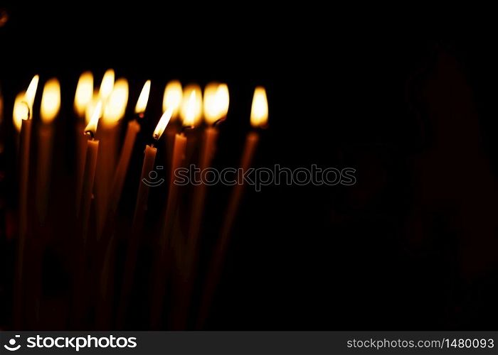 a lot of Candles burning on a black background. copy space. selective focus.. a lot of Candles burning on a black background. copy space. selective focus