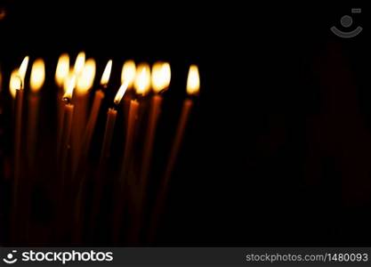 a lot of Candles burning on a black background. copy space. selective focus.. a lot of Candles burning on a black background. copy space. selective focus