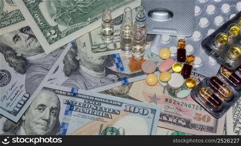 a lot of medical pills in different colors and capsules on a dollar bills, top view. banknotes and drugs